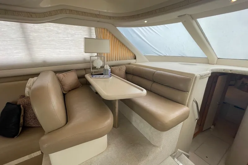 Slide: The Image of Interior of 1998 Sea Ray 480 Sedan Bridge with beige seating and table. - 35