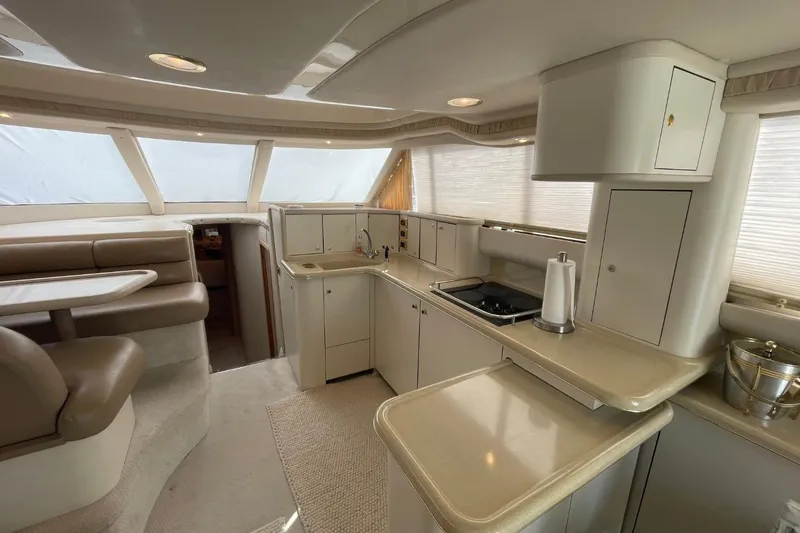 Slide: The Image of 1998 Sea Ray 480 Sedan Bridge interior with kitchen and dining area. - 38