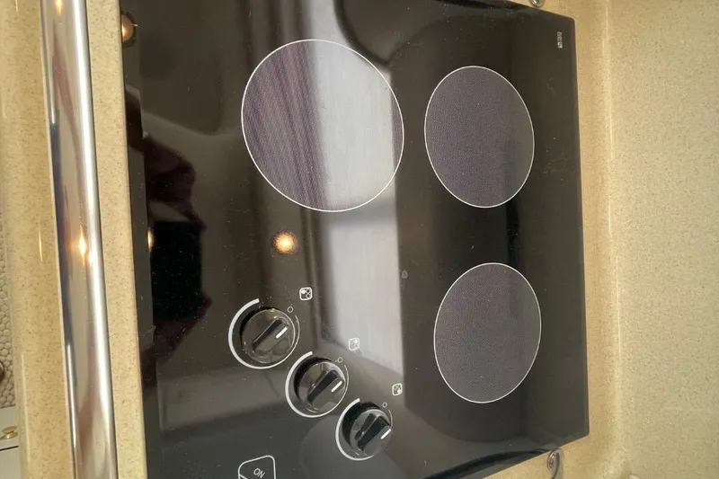 Slide: The Image of Stovetop on 1998 Sea Ray 480 Sedan Bridge yacht, featuring three burners and control knobs. - 39