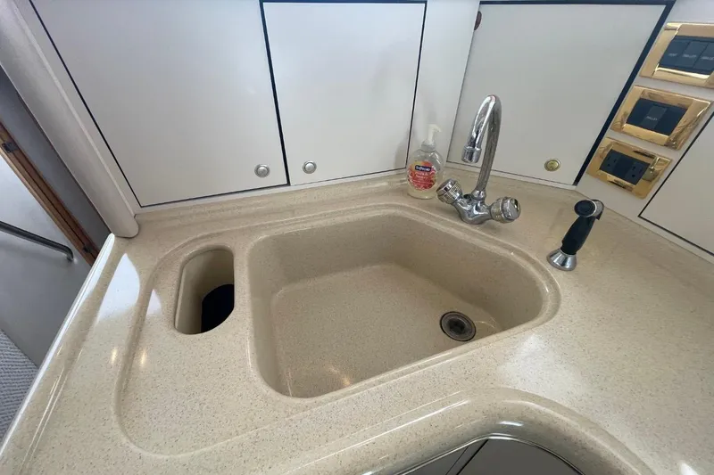 Slide: The Image of Kitchen sink area in 1998 Sea Ray 480 Sedan Bridge yacht, featuring faucet and soap dispenser. - 41