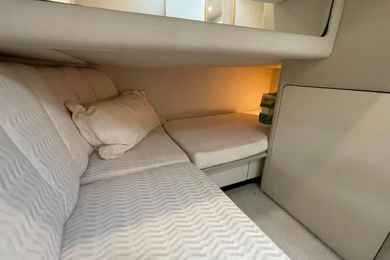 Slide: The Image of Cozy cabin interior of 1998 Sea Ray 480 Sedan Bridge with soft lighting and bedding. - 46