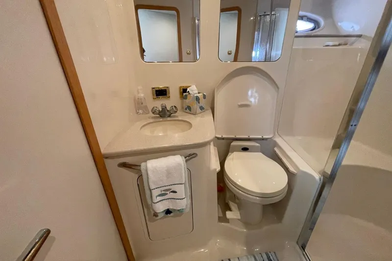 Slide: The Image of 1998 Sea Ray 480 Sedan Bridge bathroom with sink, toilet, and shower. - 52