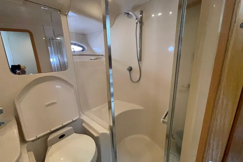 Slide: The Image of Bathroom interior of 1998 Sea Ray 480 Sedan Bridge yacht, featuring shower and toilet. - 53