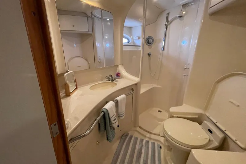 Slide: The Image of Luxurious bathroom in 1998 Sea Ray 480 Sedan Bridge yacht, featuring shower and vanity. - 56