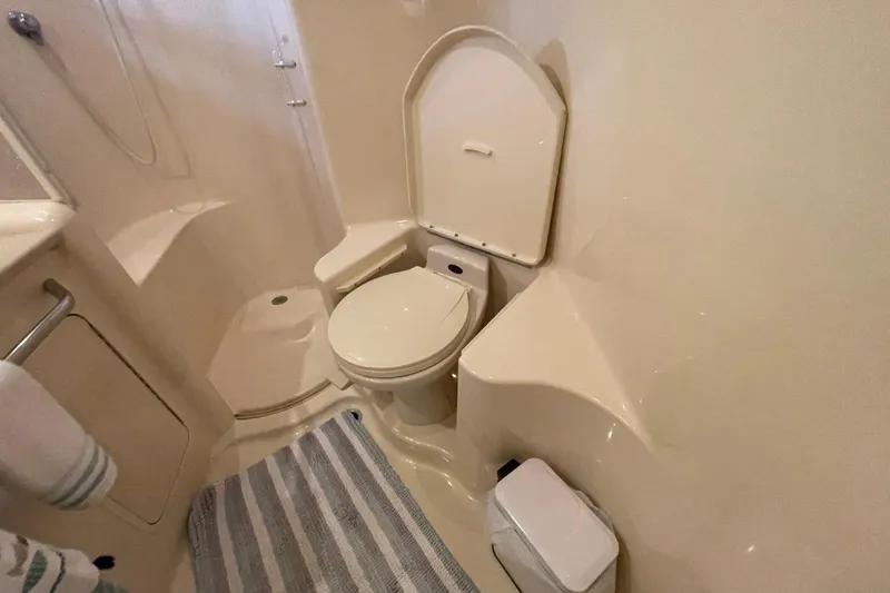 Slide: The Image of Bathroom interior of 1998 Sea Ray 480 Sedan Bridge yacht, featuring toilet and shower. - 57