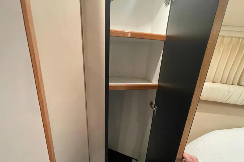 Slide: The Image of Open cabinet with wooden shelves inside a 1998 Sea Ray 480 Sedan Bridge yacht. - 60