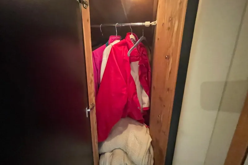 Slide: The Image of Closet with red jackets and blankets inside a 1998 Sea Ray 480 Sedan Bridge. - 61