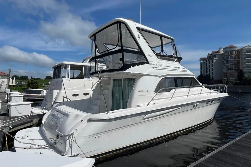 Slide: The Image of 1998 Sea Ray 480 Sedan Bridge yacht docked at marina under blue sky. - 8