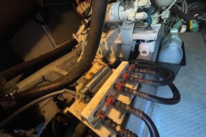 Slide: The Image of Engine room of a 1998 Sea Ray 480 Sedan Bridge with visible hoses and components. - 93