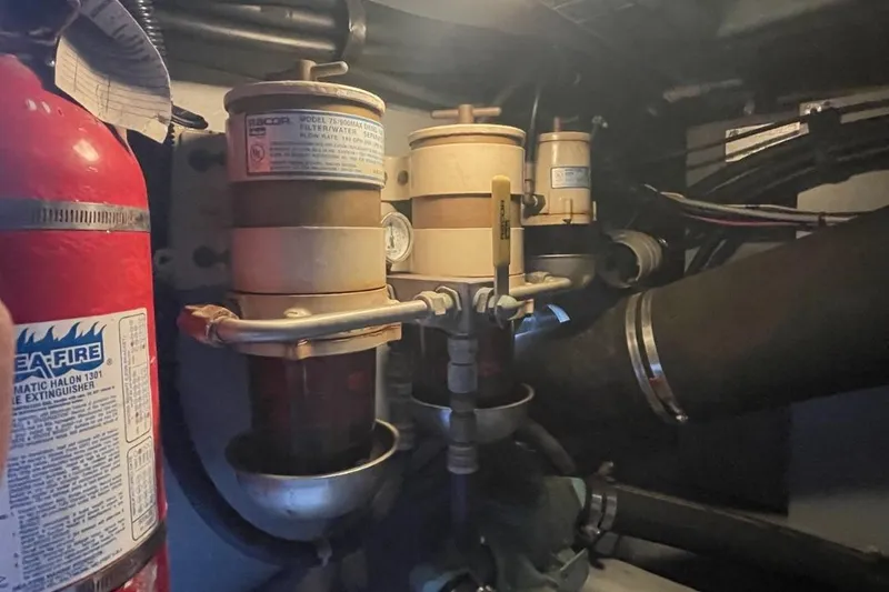 Slide: The Image of Engine room of 1998 Sea Ray 480 Sedan Bridge with fuel filters and fire extinguisher. - 94