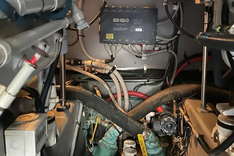 Slide: The Image of Engine room of a 1998 Sea Ray 480 Sedan Bridge with visible wiring and components. - 99