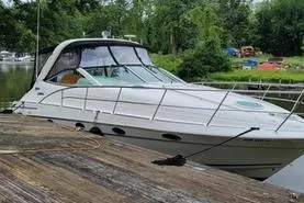 Slide: The Image of 2000 Doral 360 SE boat docked by a lush, green riverside. - 2