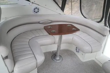 Slide: The Image of Interior of 2000 Doral 360 SE boat with curved seating and wooden table. - 23