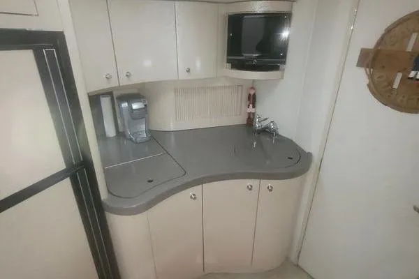 Slide: The Image of 2000 Doral 360 SE boat kitchenette with compact appliances and storage cabinets. - 8