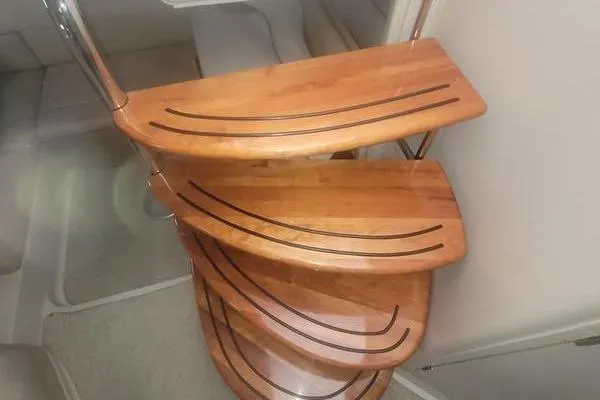 Slide: The Image of Wooden spiral staircase inside 2000 Doral 360 SE boat, featuring sleek curved design. - 9