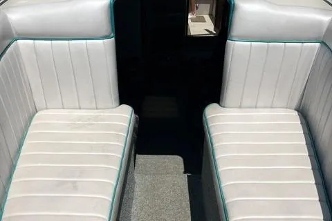 Slide: The Image of 1979 Wellcraft Scarab 38 interior with white cushioned seating and teal accents. - 6