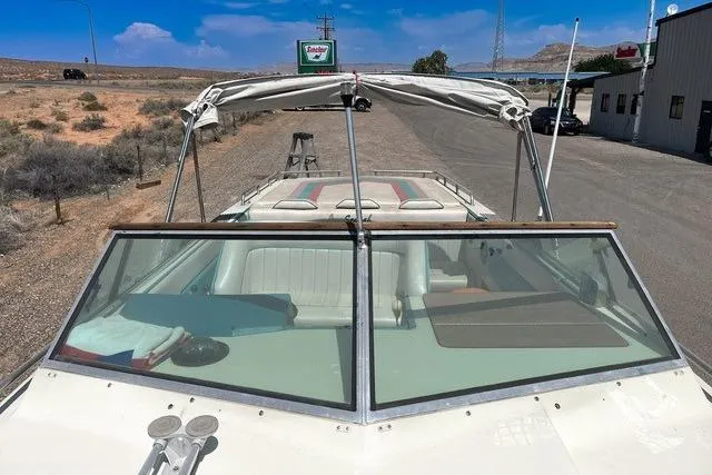 Slide: The Image of 1979 Wellcraft Scarab 38 boat with canopy, parked on a sunny roadside near a building. - 9