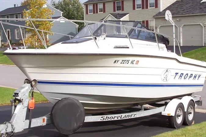 Slide: The Image of White 1993 Trophy 2002 Wa boat on trailer, parked in suburban driveway. - 4