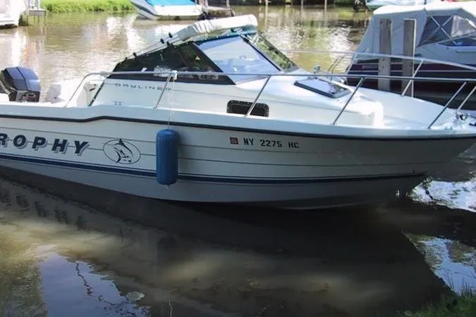 Slide: The Image of 1993 Trophy 2002 Wa boat docked on calm water, featuring sleek design and blue fender. - 5
