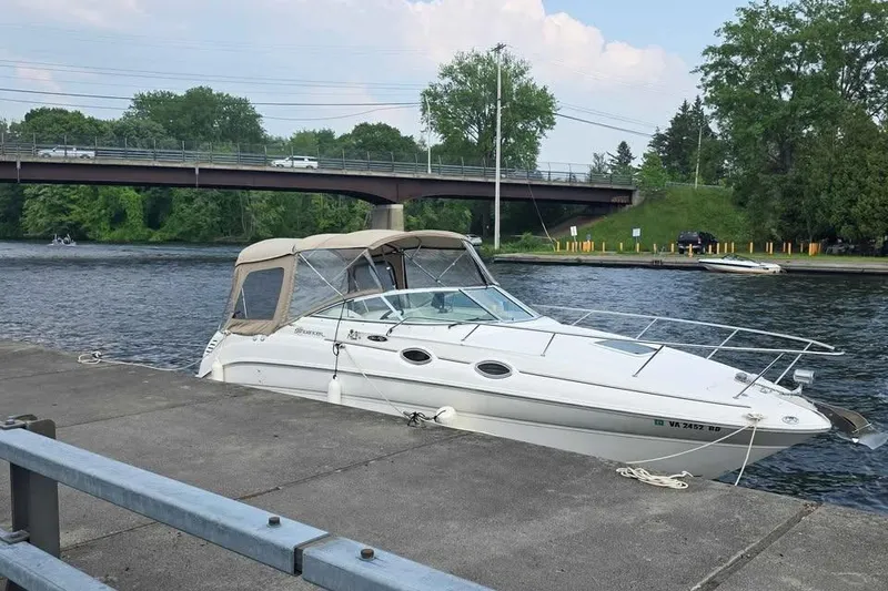 Slide: The Image of 2002 Sea Ray 260 Sundancer docked by a river with a bridge in the background. - 14