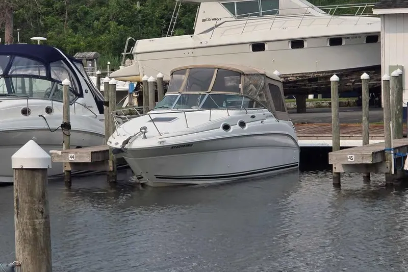 Slide: The Image of 2002 Sea Ray 260 Sundancer docked at marina, surrounded by other boats. - 16