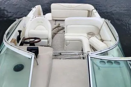 Slide: The Image of 2002 Sea Ray 260 Sundancer boat interior with white seating and steering wheel. - 2