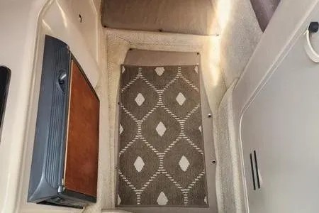 Slide: The Image of Interior view of a 2002 Sea Ray 260 Sundancer with patterned carpet and compact fridge. - 28