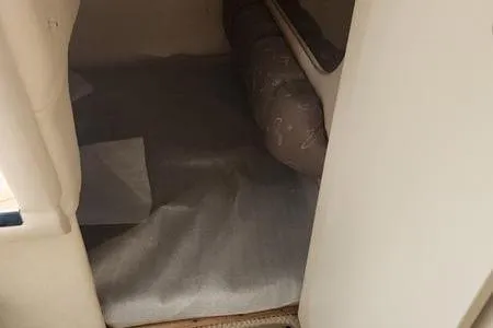 Slide: The Image of 2002 Sea Ray 260 Sundancer cabin interior with cushioned seating and carpeted floor. - 31