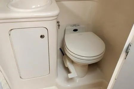 Slide: The Image of 2002 Sea Ray 260 Sundancer boat bathroom with compact toilet and sink. - 32