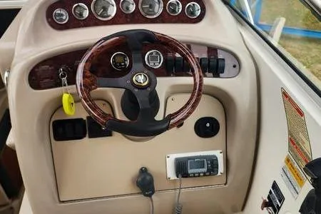 Slide: The Image of 2002 Sea Ray 260 Sundancer boat dashboard with steering wheel and control panel. - 37