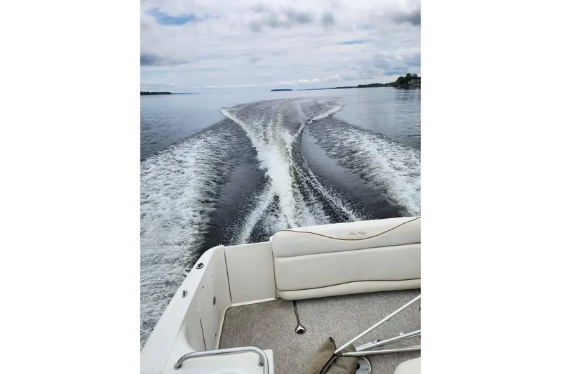 Slide: The Image of 2002 Sea Ray 260 Sundancer cruising on calm waters, leaving a wake behind. - 4