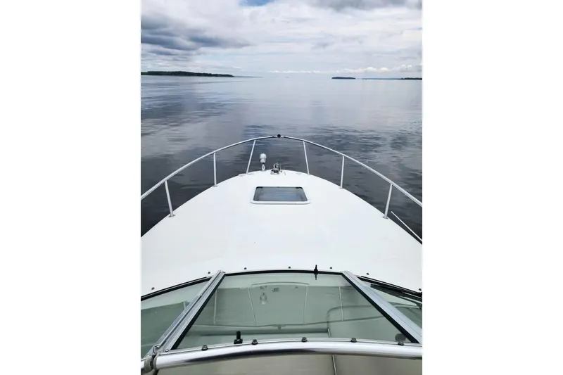 Slide: The Image of 2002 Sea Ray 260 Sundancer cruising on calm waters under cloudy skies. - 9