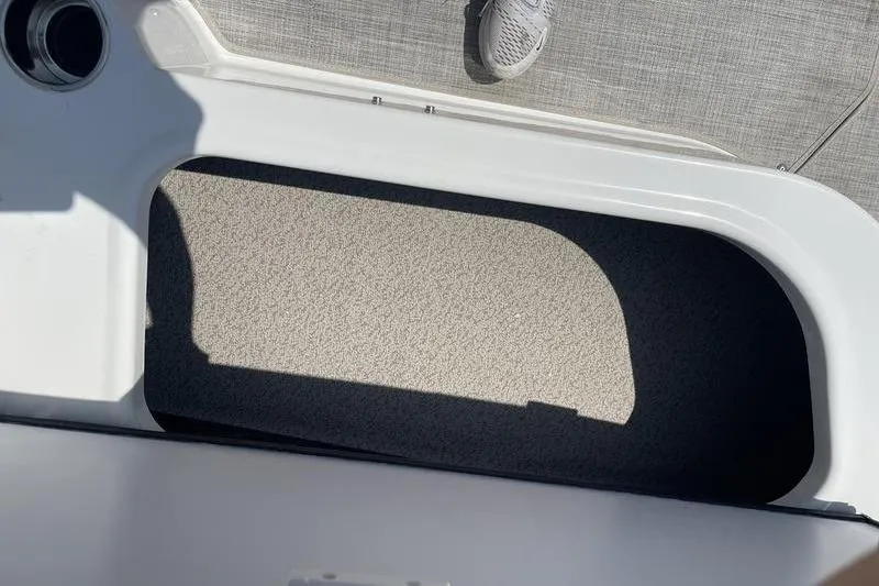 Slide: The Image of Storage compartment on a 2025 Stingray 182C boat, featuring a textured interior. - 13