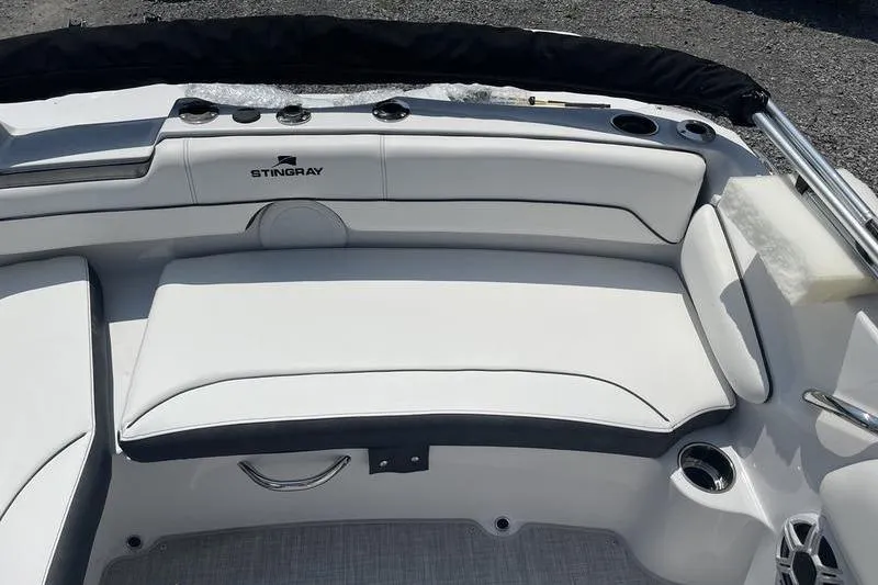 Slide: The Image of 2025 Stingray 182C boat interior with white cushioned seating and cup holders. - 17