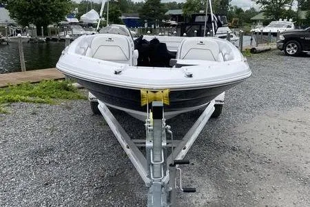 Slide: The Image of 2025 Stingray 182C boat on trailer, parked on gravel near marina. - 3