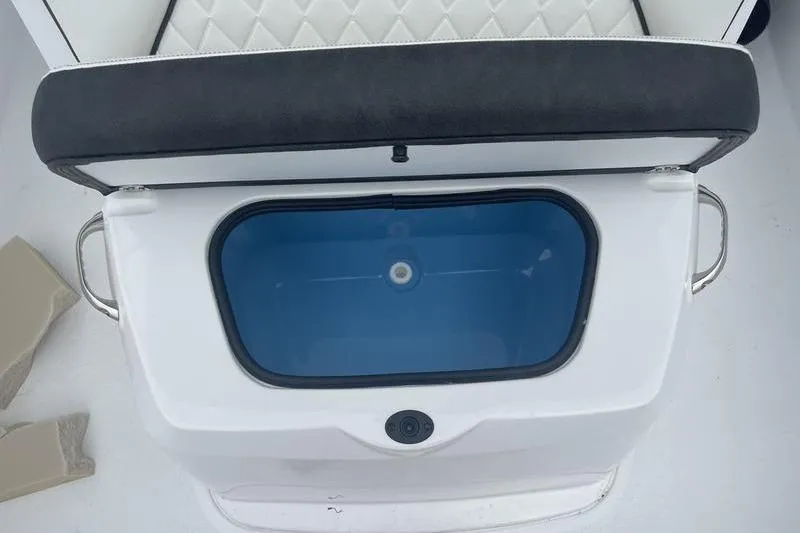 Slide: The Image of Open storage compartment on 2025 Stingray 173CC boat with cushioned seat. - 13