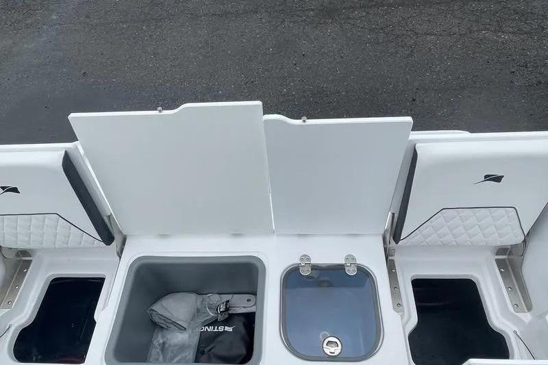 Slide: The Image of 2025 Stingray 173CC boat storage compartments with open lids, showcasing interior features. - 17