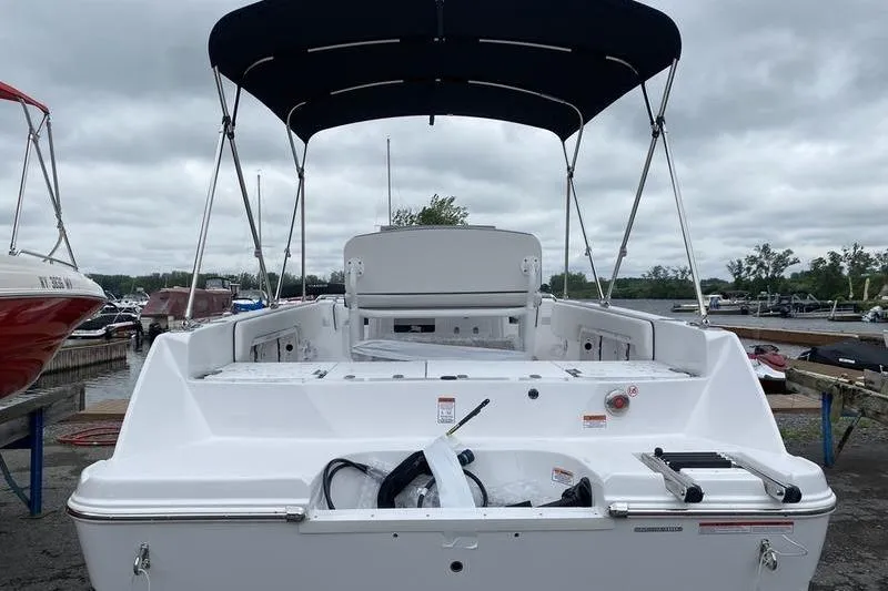 Slide: The Image of 2025 Stingray 173CC boat with canopy, docked under cloudy skies. - 6