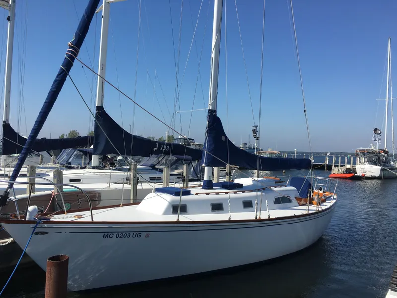 Slide: The Image of 1967 Islander 37 sailboat docked at marina, featuring wooden trim and nautical equipment. - 15
