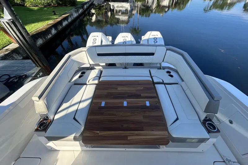 Slide: The Image of 2023 Tiara Yachts 38 LS luxury seating area with wooden table and cup holders. - 13