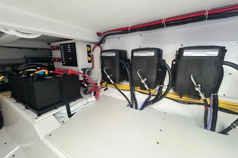 Slide: The Image of Engine compartment of 2023 Tiara Yachts 38 LS, featuring power steering pumps and battery system. - 18
