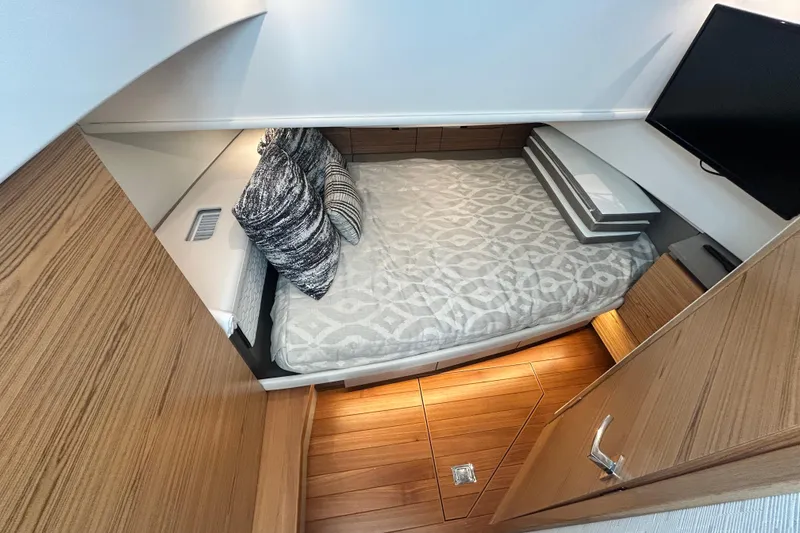 Slide: The Image of 2023 Tiara Yachts 38 LS cabin interior with bed, pillows, and TV. - 30