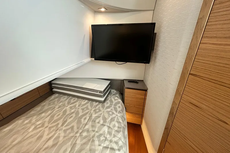Slide: The Image of 2023 Tiara Yachts 38 LS cabin interior with TV and modern wood accents. - 31
