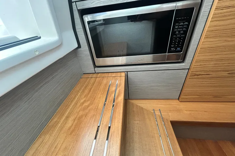 Slide: The Image of 2023 Tiara Yachts 38 LS interior with microwave and wooden cabinetry. - 37