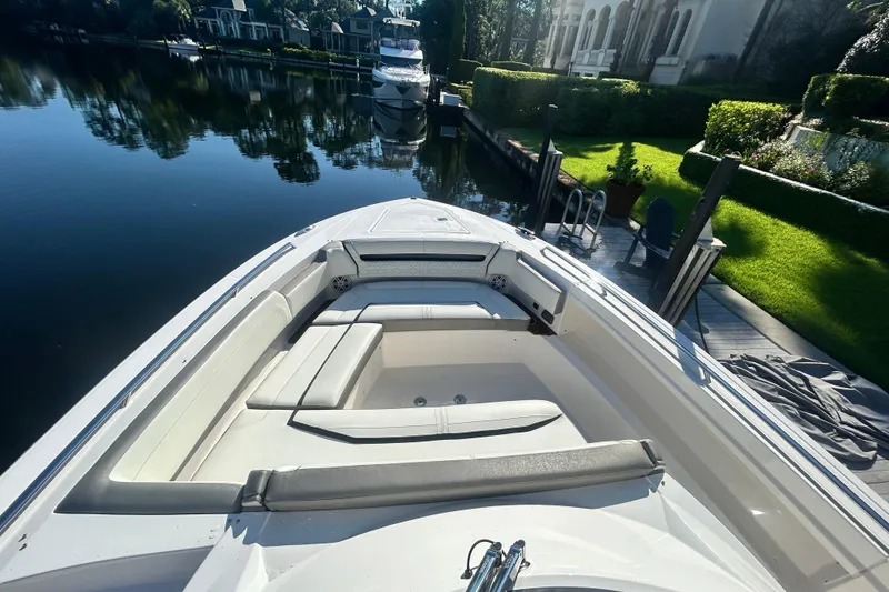 Slide: The Image of 2023 Tiara Yachts 38 LS boat with spacious seating, docked by a lush garden. - 51