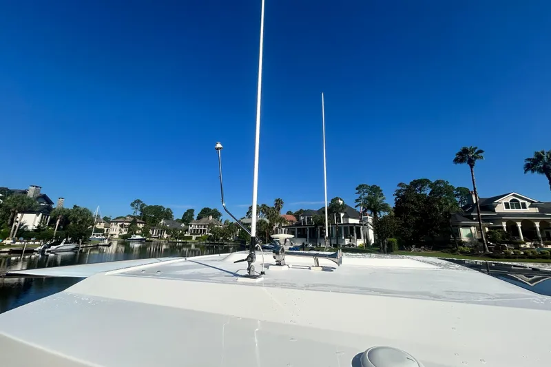 Slide: The Image of 2023 Tiara Yachts 38 LS on calm water, surrounded by luxury homes and clear blue sky. - 60