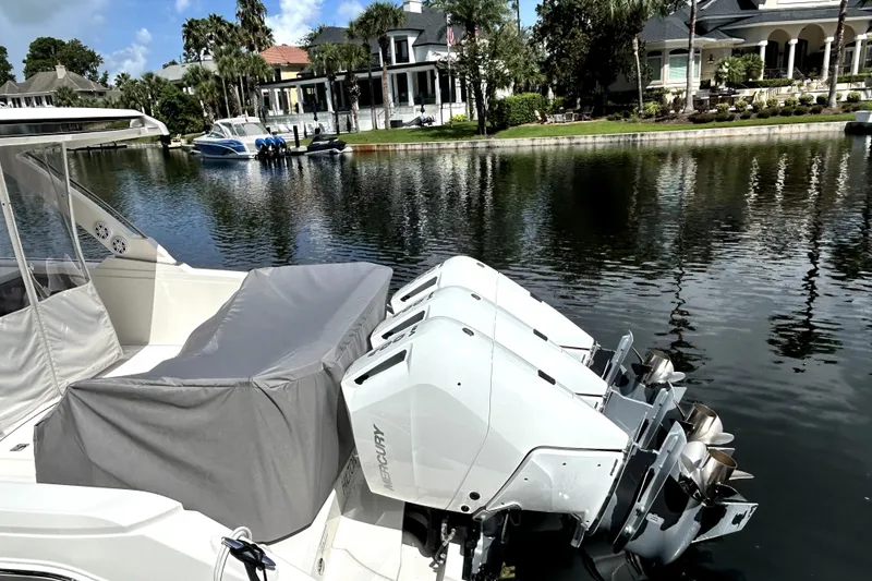 Slide: The Image of 2023 Tiara Yachts 38 LS with triple outboard engines docked by waterfront homes. - 9