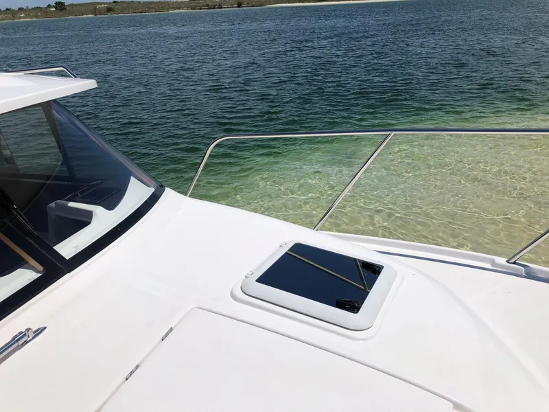 Slide: The Image of 2025 Cutwater C-32 Sedan boat on clear water, showcasing sleek design. - 14