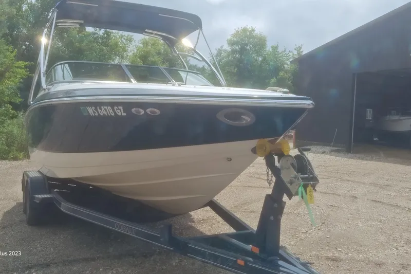 Slide: The Image of 2006 Cobalt 240 boat on trailer, parked outdoors near a building. - 1