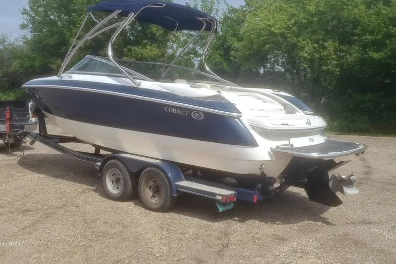 Slide: The Image of 2006 Cobalt 240 boat on trailer, blue and white, parked outdoors. - 3